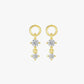 Gold earrings with clear gemstones on a white background
