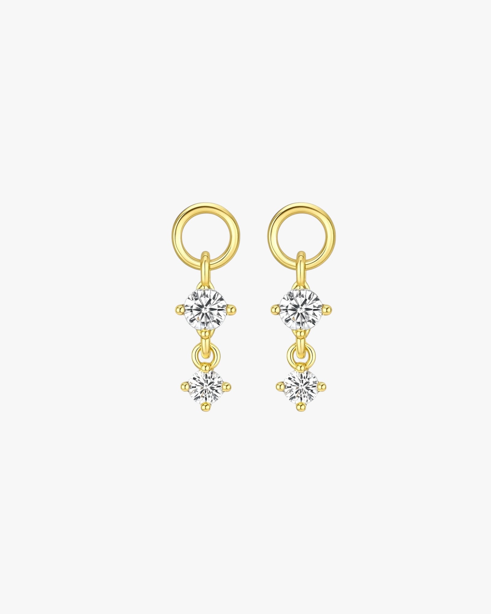 Gold earrings with clear gemstones on a white background