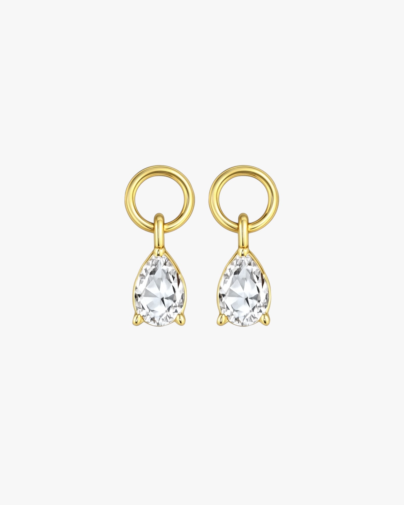 Gold earrings with clear gemstones on a white background