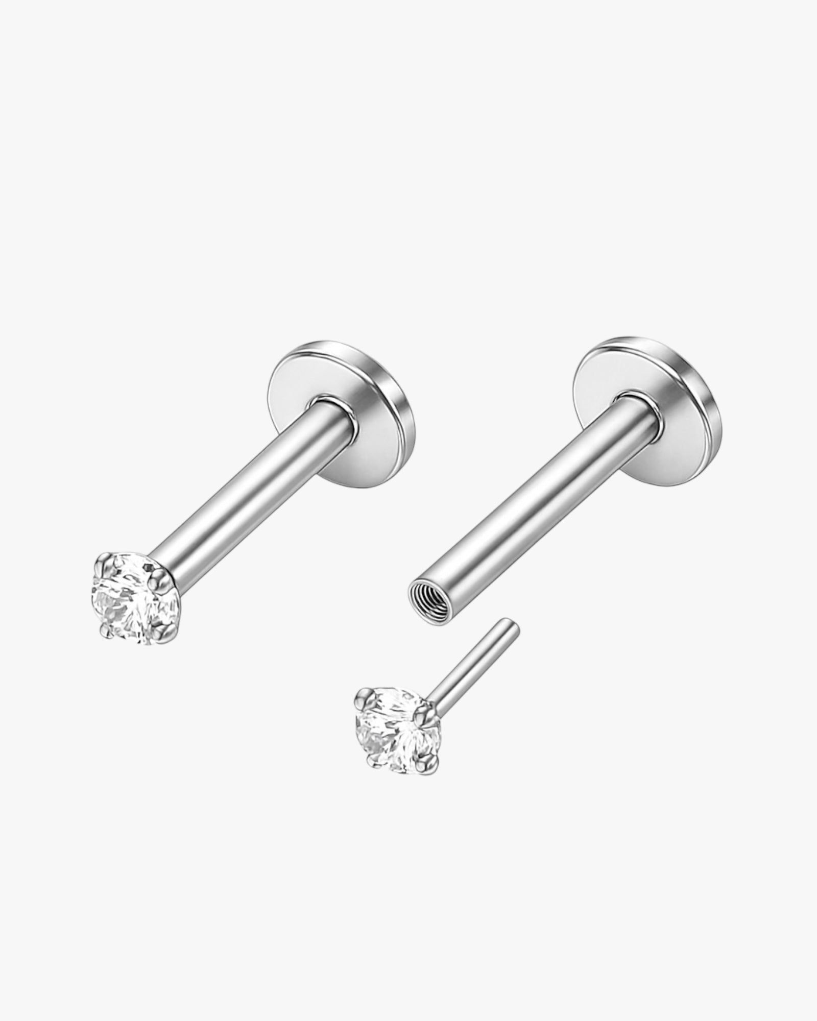 Set of silver nose rings with clear gemstones on a white background