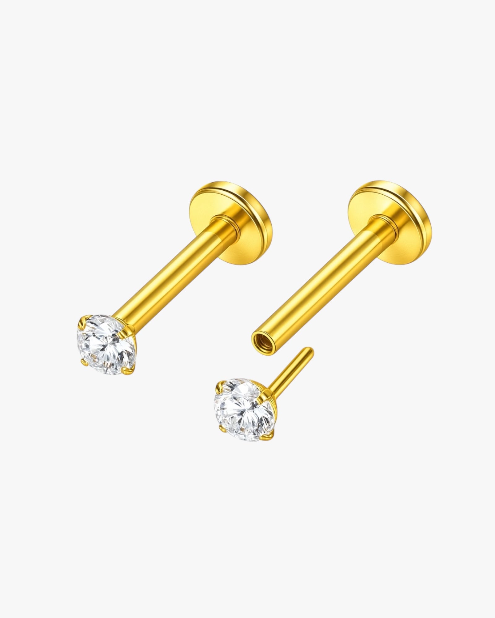 Gold stud earrings with clear gemstones on a white background
