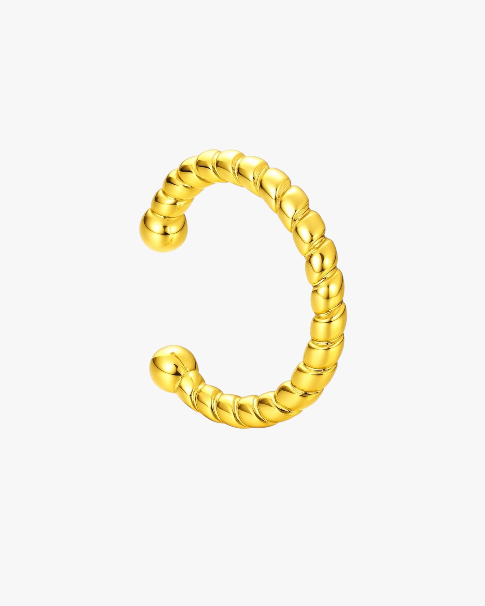 Gold ear cuff with a textured design on a white background