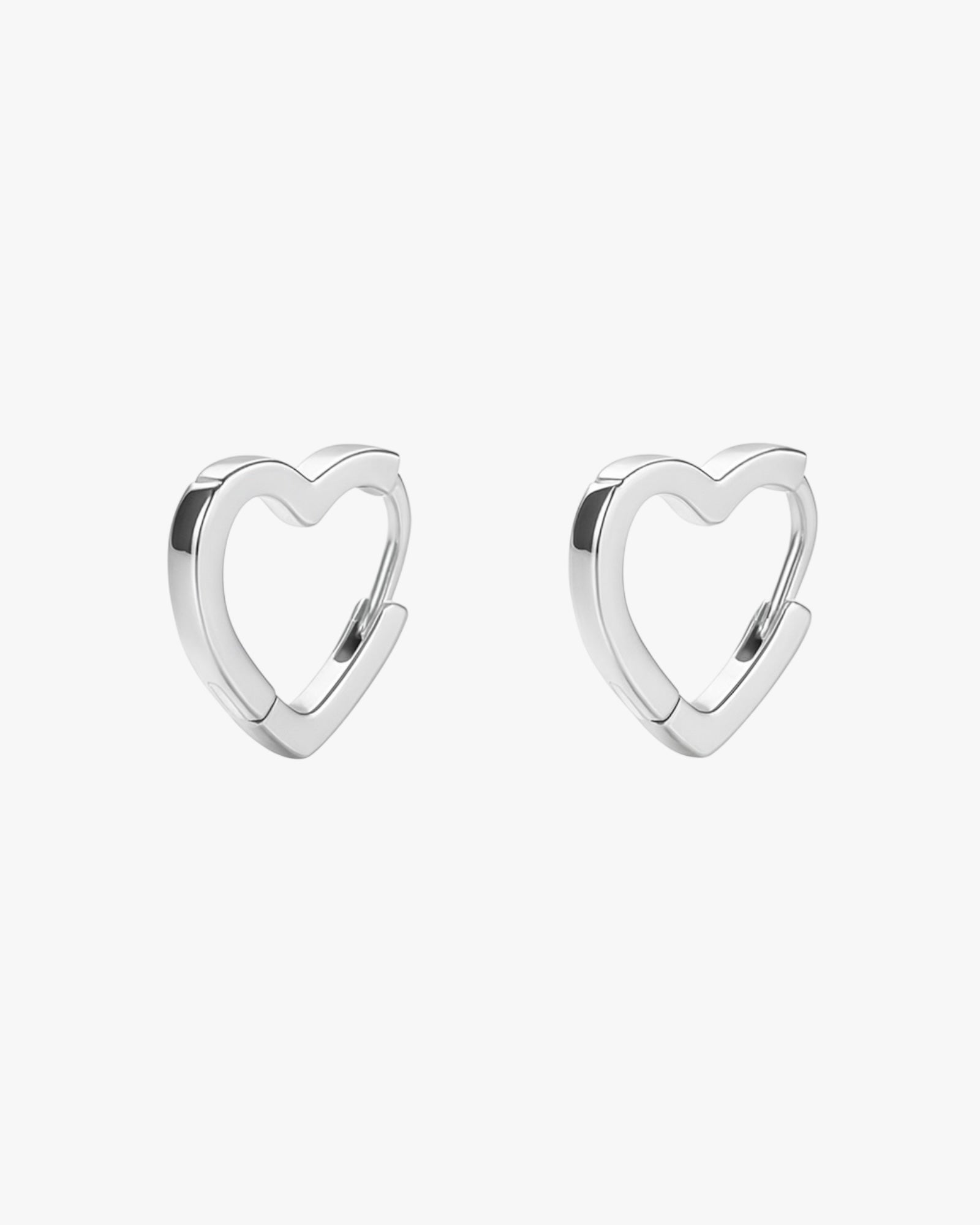 Heart-shaped silver hoop earrings on a white background