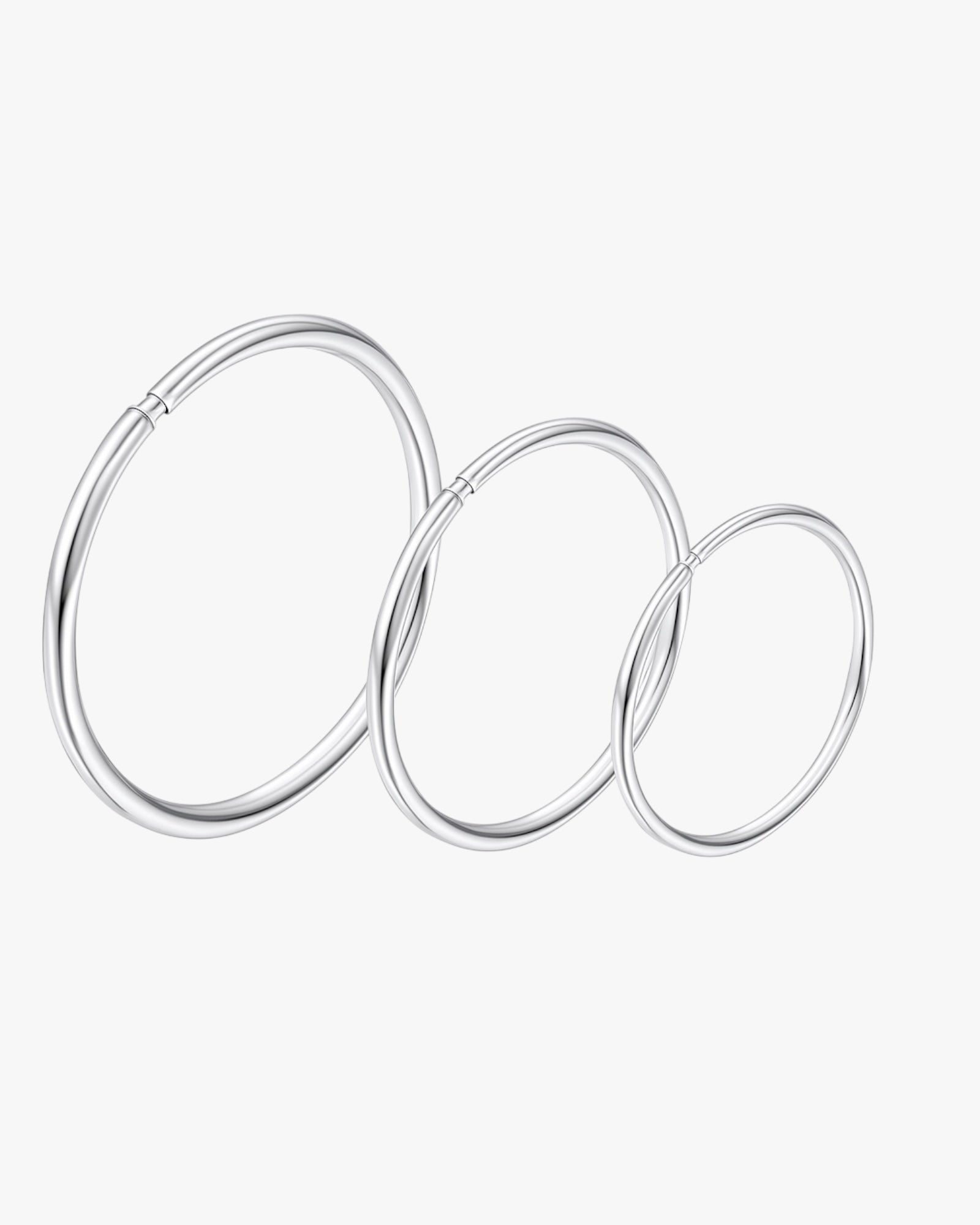 Set of three silver hoop earrings on a white background