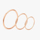 Set of rose gold hoop earrings on a light gray background