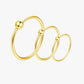 Set of three gold hoop earrings on a white background