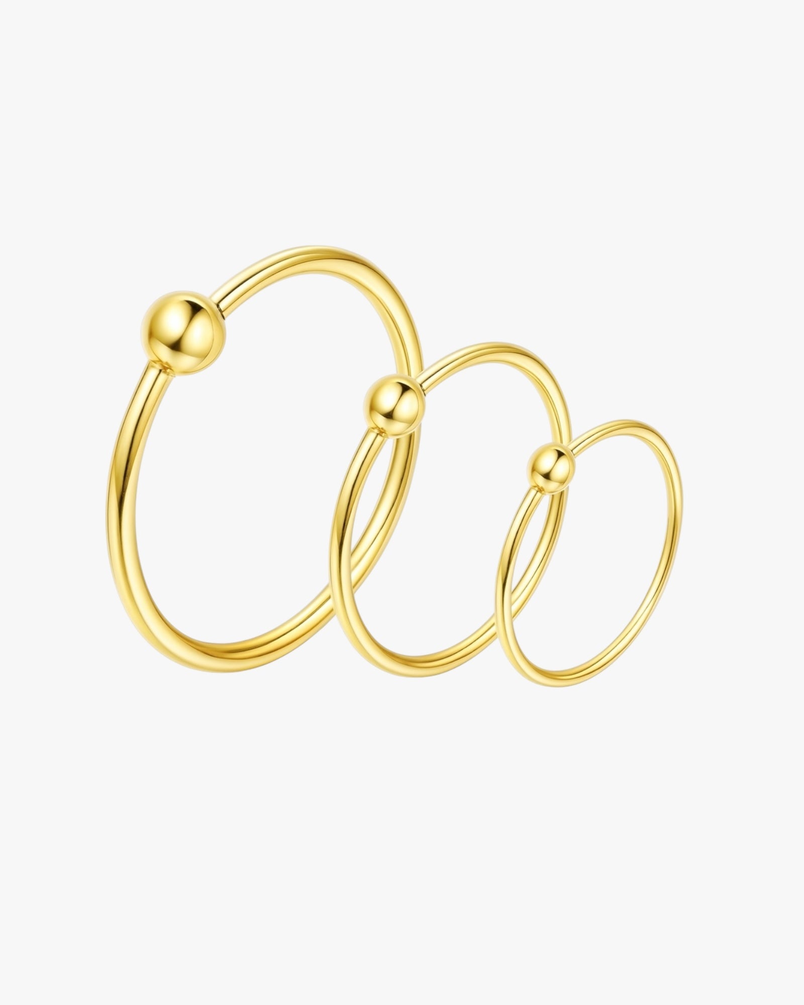 Set of three gold hoop earrings on a white background