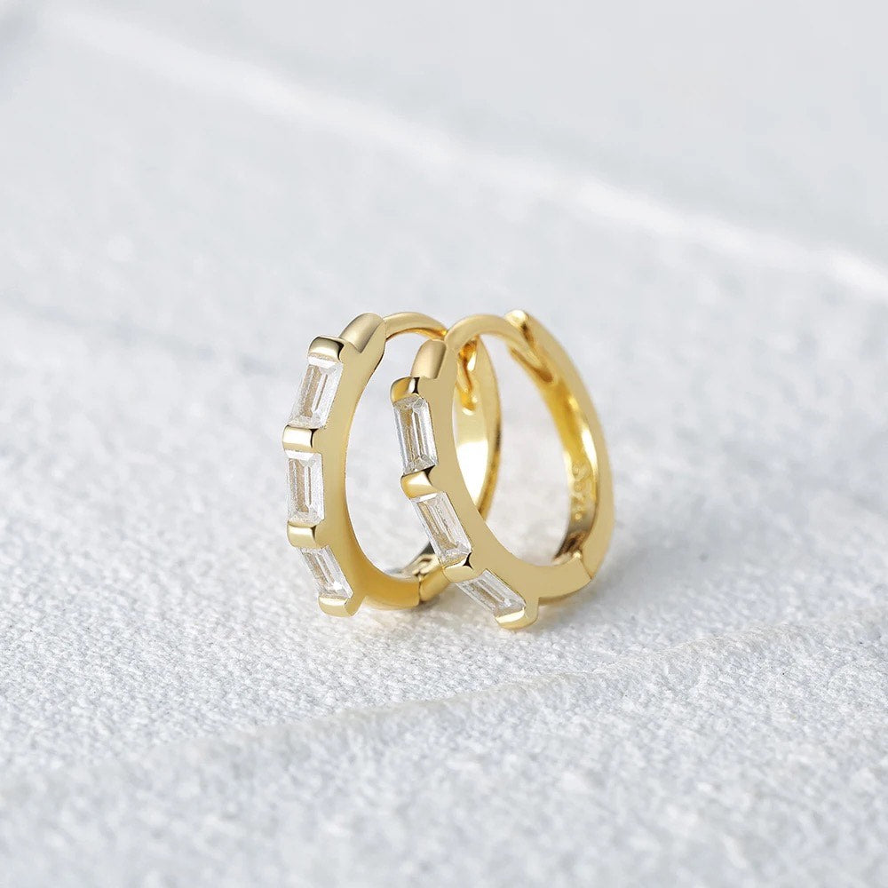 "Image: Pave clicker hoops elegantly displayed against a sleek grey background."