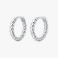 Pair of silver hoop earrings with twisted design on a white background