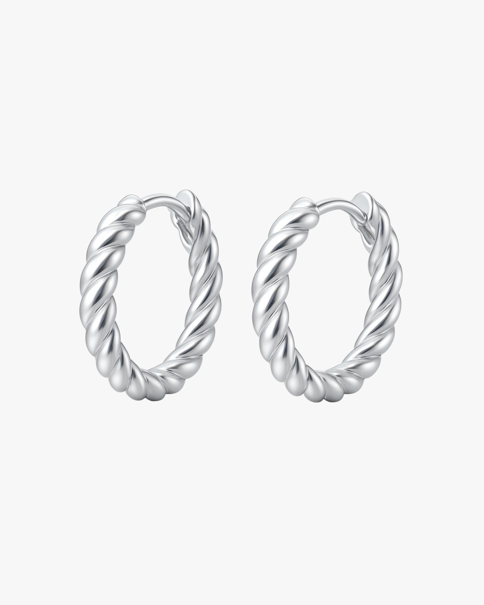 Pair of silver hoop earrings with twisted design on a white background