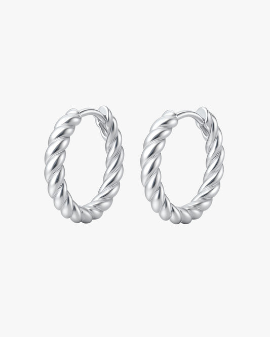 Pair of silver hoop earrings with twisted design on a white background