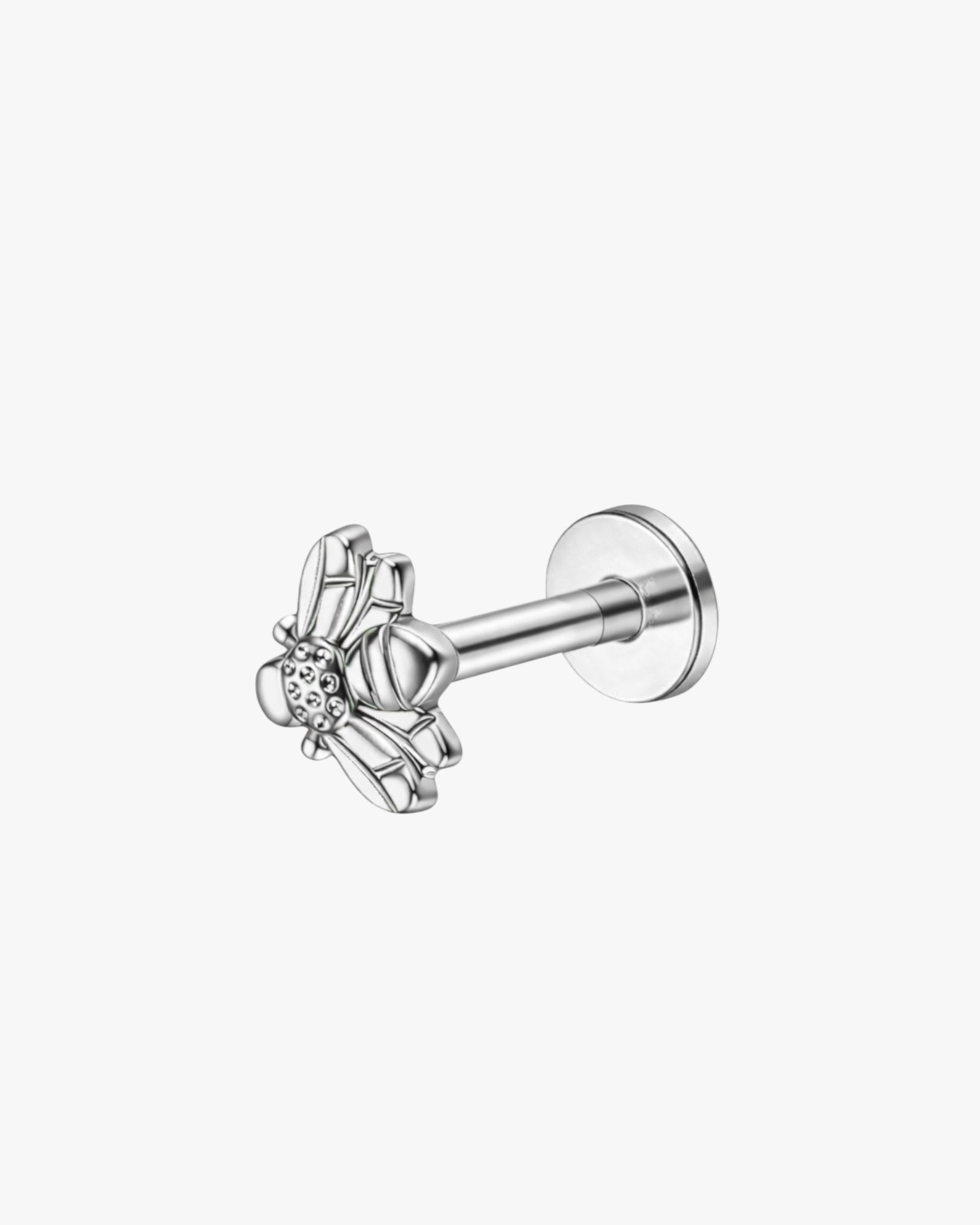Silver ear cuff with a bee design on a white background