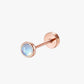 Rose gold stud earring with a gemstone on a white background