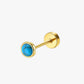 Gold stud earring with a blue gemstone on a white background