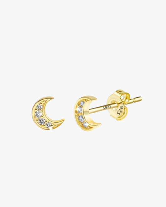 A pair of gold-plated brass stud earrings with one stud featuring a moon and the other featuring a small diamond-like sparkle.