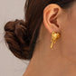 "Two pairs of earrings displayed in ear