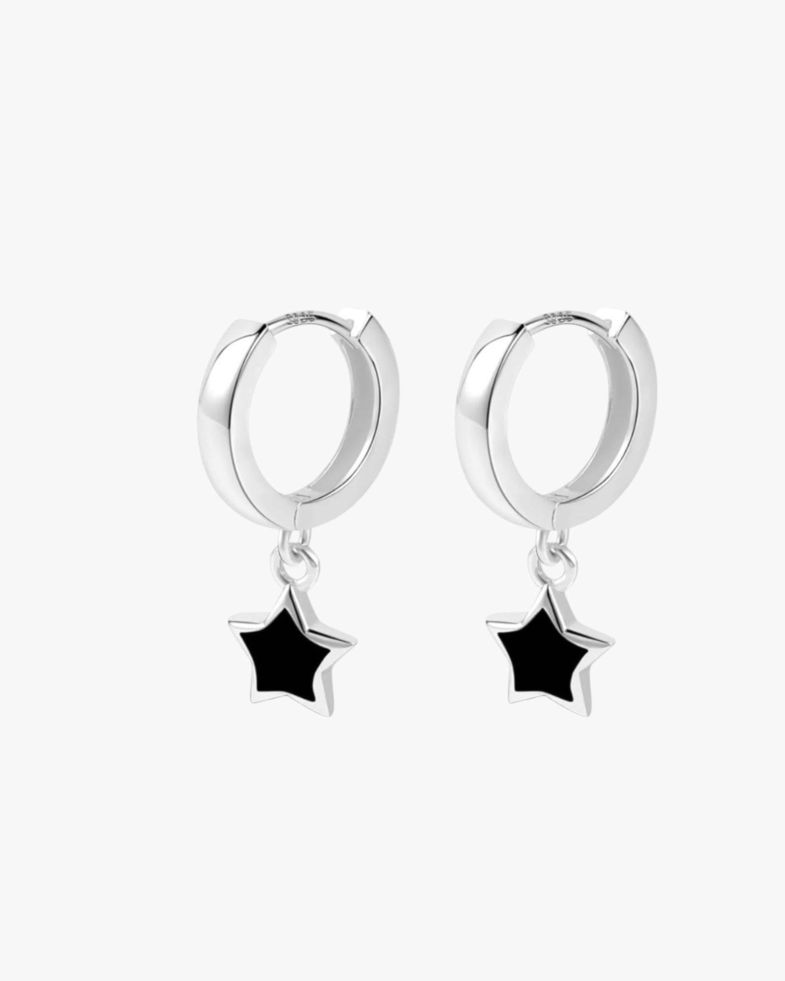 A pair of silver-colored hoop earrings with black stars attached to the hoops, presented against a white background.