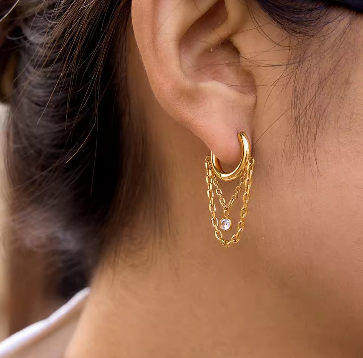 Gold hoop multiple chain earrings worn on lobe piercing