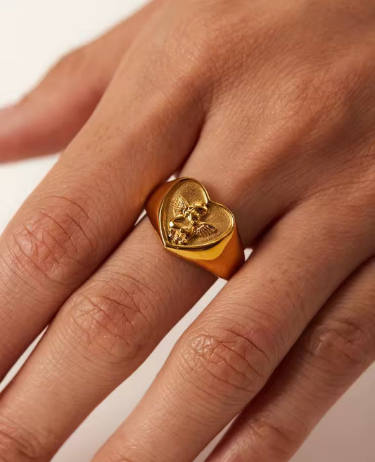 Gold plated angel cherub heart signet ring on a finger